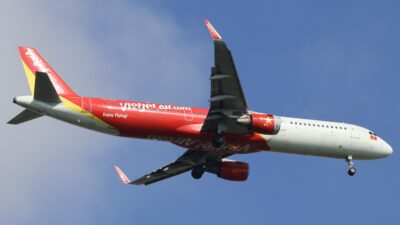 Vietjet Airbus A321-211 repülőgép piros-fehér festéssel, kinyitott futóművel Szingapúrnál